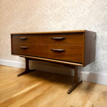 Load image into Gallery viewer, Wooden dresser with four drawers against a patterned wall.
