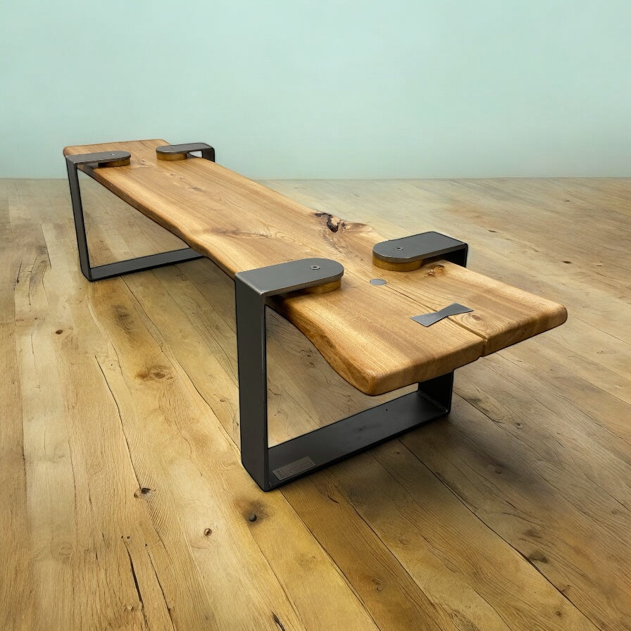 Wooden bench with black metal legs on a wooden floor