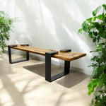 Load image into Gallery viewer, Wooden bench with black metal legs in a room with plants
