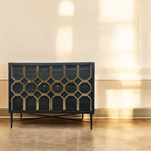 Decorative black cabinet with geometric pattern in a room with beige walls and wooden floor.