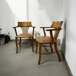 Load image into Gallery viewer, Two wooden chairs with leather seats in a minimalistic room.
