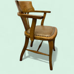 Load image into Gallery viewer, Wooden armchair with leather seat on a light green background
