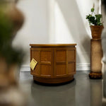 Load image into Gallery viewer, Wooden side table with a tag on a gray floor against a white wall
