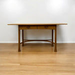 Load image into Gallery viewer, Wooden table with two drawers on a wooden floor against a white wall
