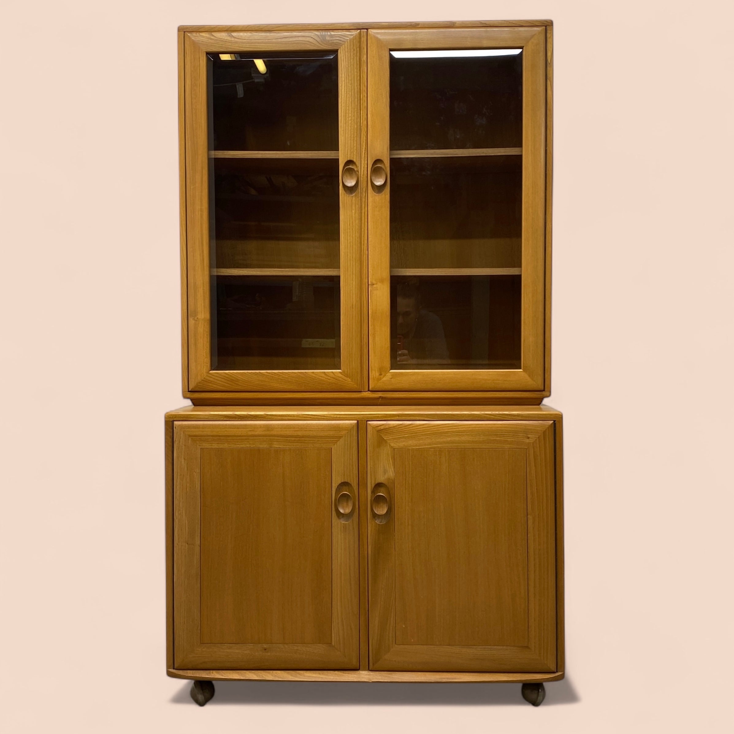 Wooden cabinet with glass doors on a beige background
