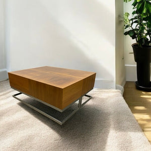 Wooden coffee table in a room with a plant and light-colored floor.