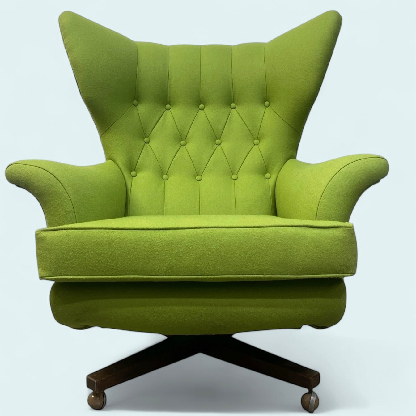 Green armchair with tufted backrest on a white background