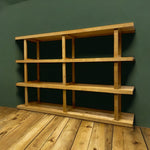 Load image into Gallery viewer, Wooden bookshelf against a green wall
