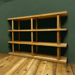 Wooden bookshelf against a green wall