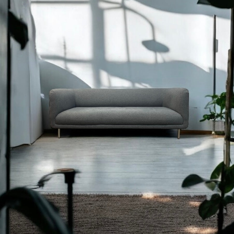 Gray sofa in a modern room with large windows and plants