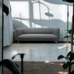Load image into Gallery viewer, Gray sofa in a modern room with large windows and plants
