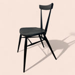 Load image into Gallery viewer, Black chair on a beige background
