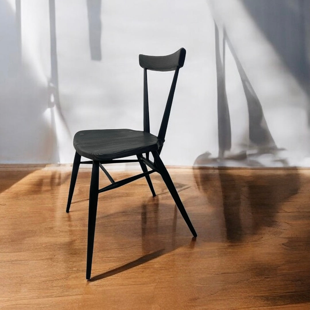 Black chair on a wooden floor with a white wall background