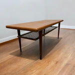 Load image into Gallery viewer, Wooden coffee table with a cane shelf on a wooden floor.
