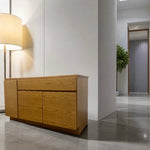 Load image into Gallery viewer, Wooden sideboard in a modern interior setting with a lamp and plant.
