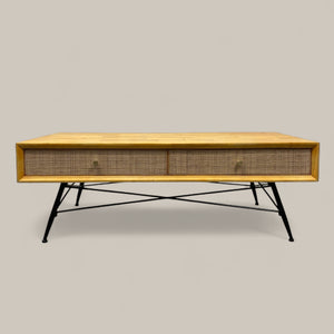 Wooden coffee table with wicker side panels on a plain background