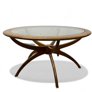 Round wooden table with glass top on a white background