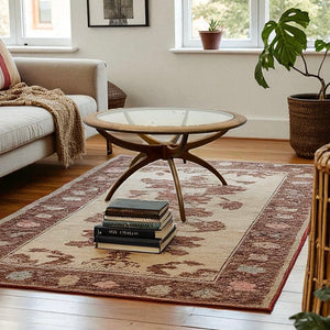 Living room with a round glass table, books, and a patterned rug.