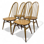 Load image into Gallery viewer, Four wooden chairs with spindle backs on a white background
