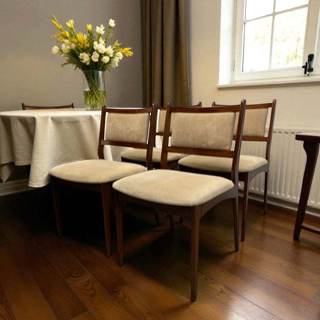Dining room with wooden chairs and a tablecloth, featuring a vase of flowers.