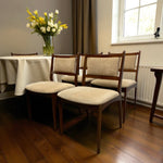 Load image into Gallery viewer, Dining room with wooden chairs and a tablecloth, featuring a vase of flowers.
