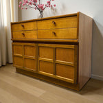 Load image into Gallery viewer, Wooden dresser with drawers and a vase of pink flowers on top in a room.
