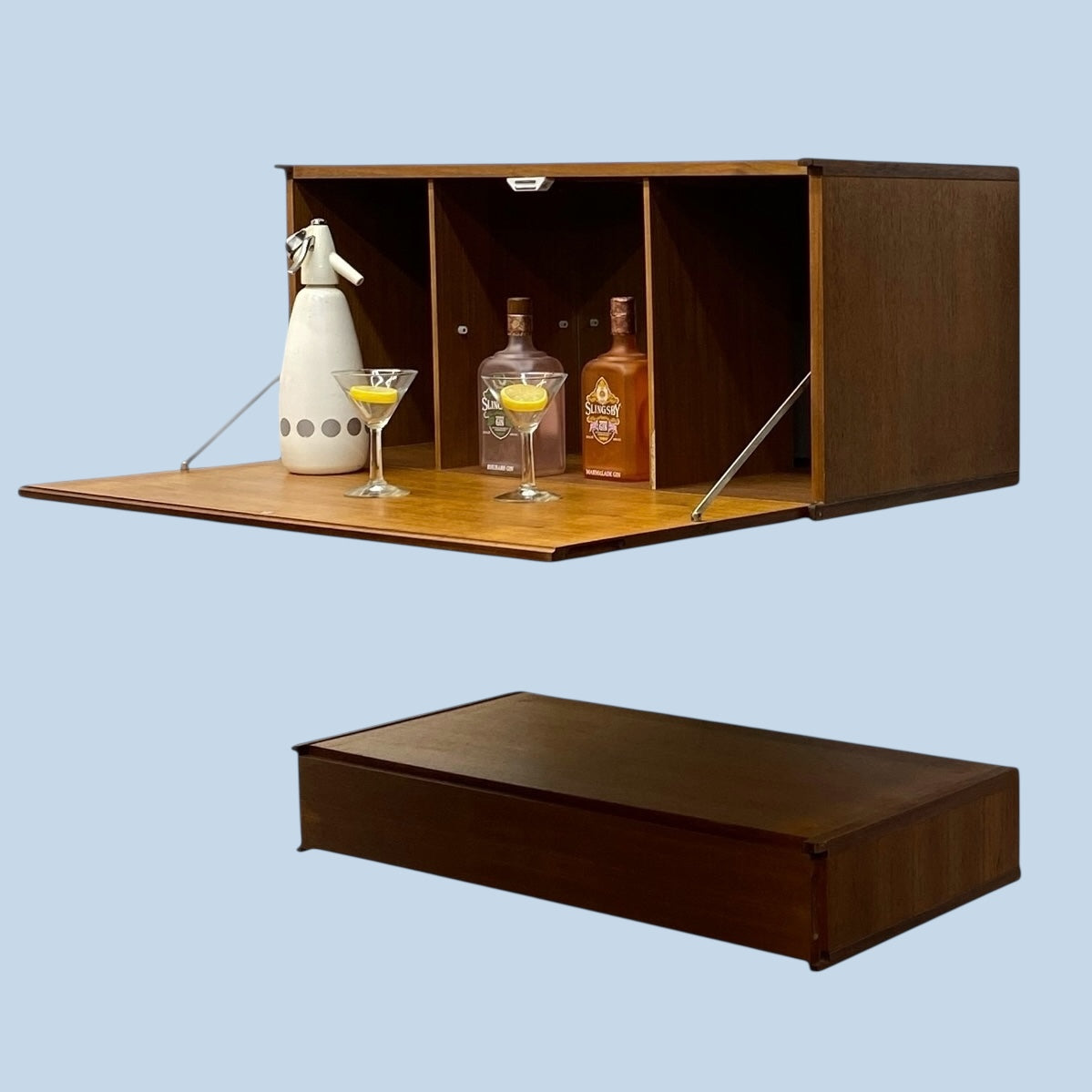 Wall-mounted bar cabinet with open shelf displaying bottles and glasses on a light blue background