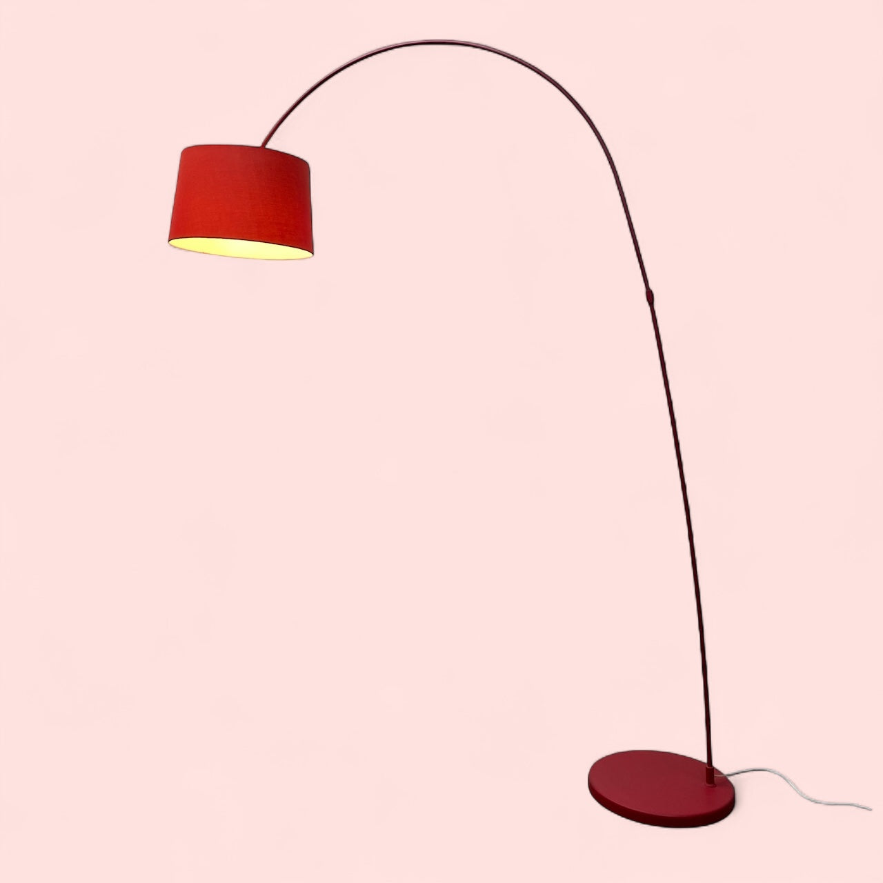 Floor lamp with a red shade and base on a pink background