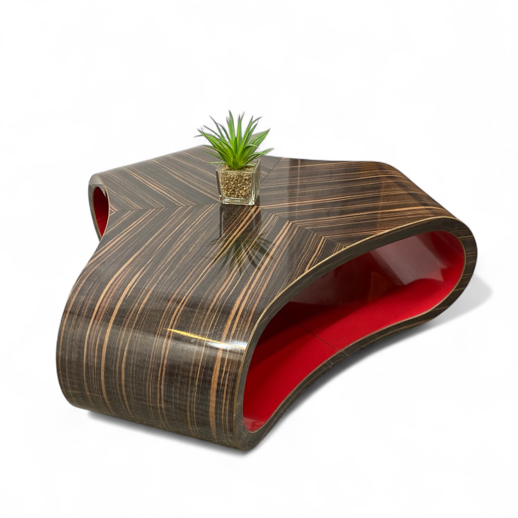 Modern coffee table with wavy design and red interior on a white background
