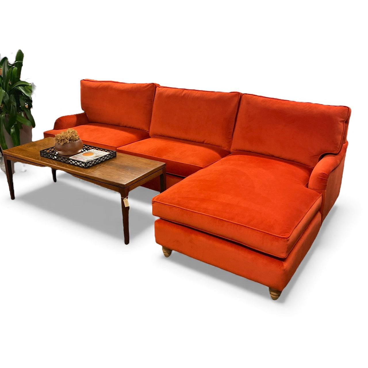 Orange sectional sofa with a wooden coffee table on a white background