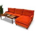 Load image into Gallery viewer, Orange sectional sofa with a wooden coffee table on a white background

