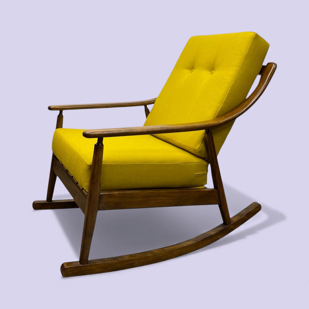 Yellow cushioned rocking chair with wooden frame on a light purple background