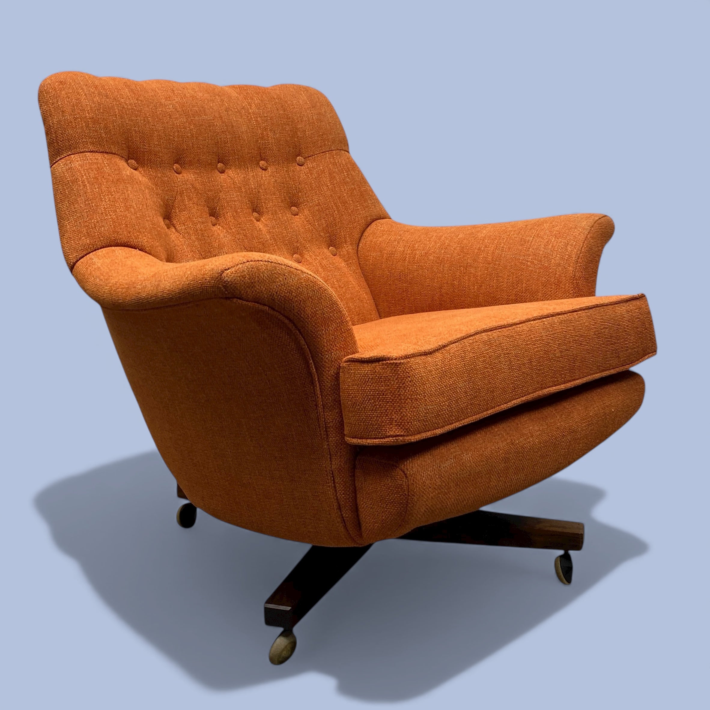 Orange armchair with tufted backrest on a light blue background