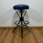 Load image into Gallery viewer, Black adjustable stool with a blue seat on a wooden floor against a white wall.
