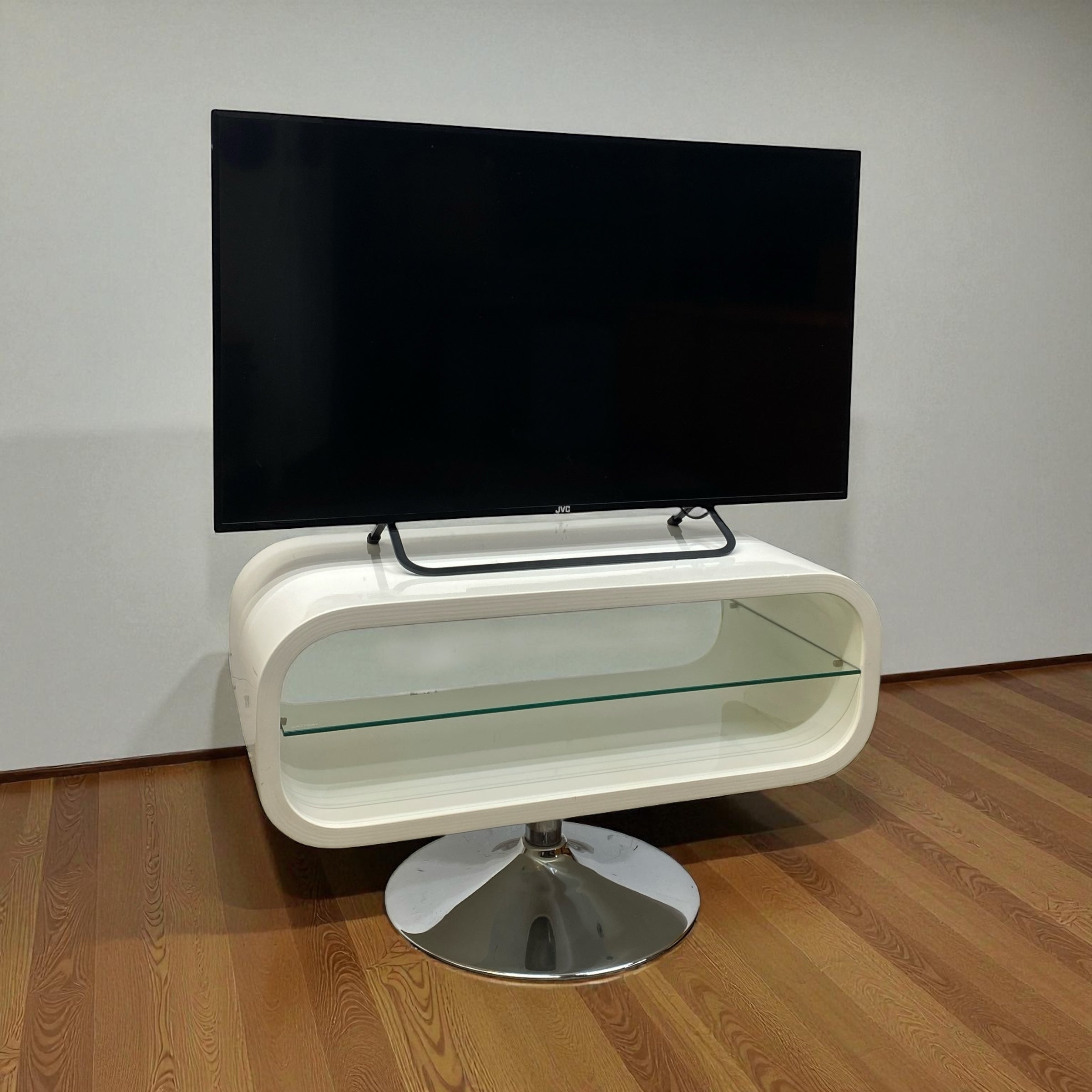 Modern white TV stand with a black flat-screen TV on a wooden floor.