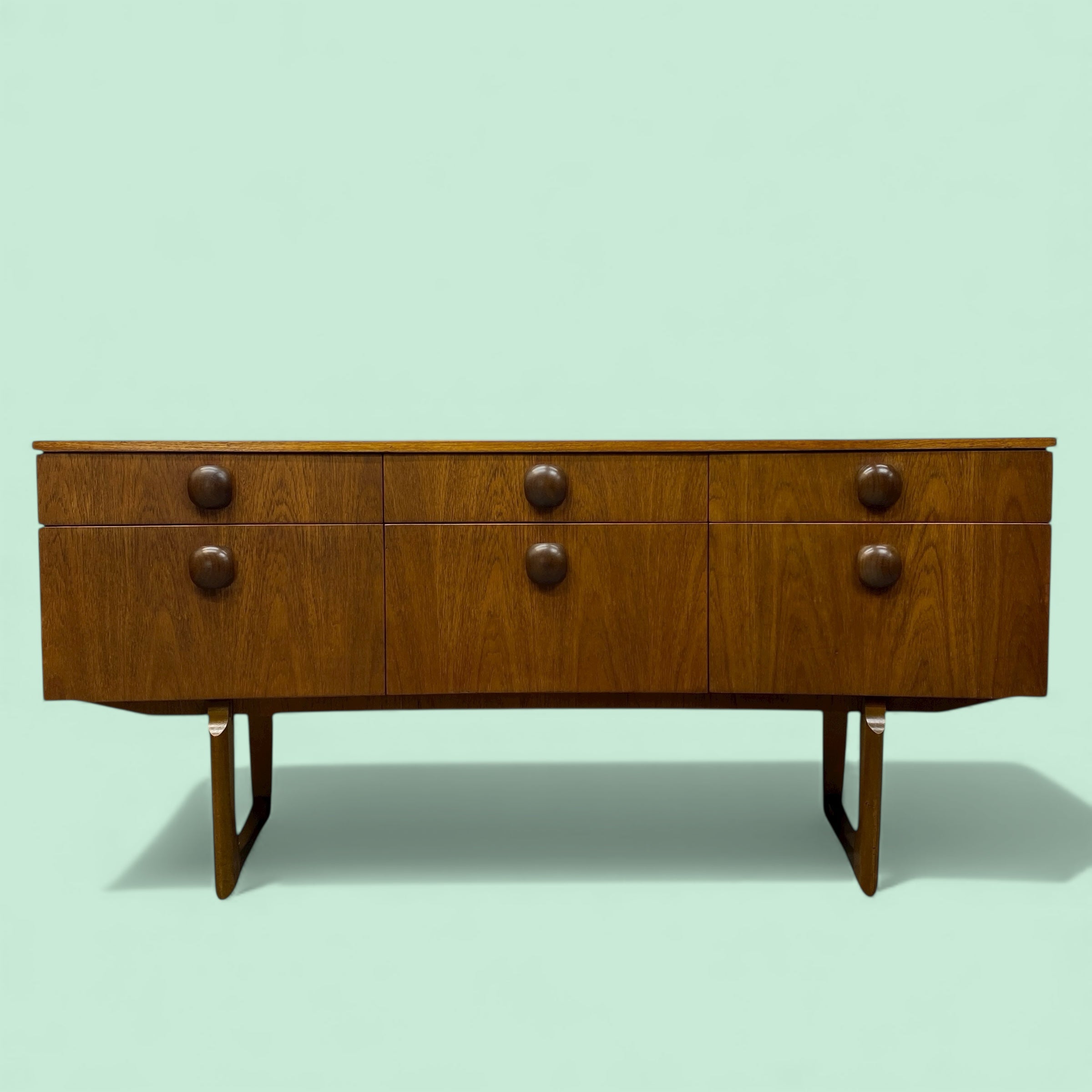 Wooden sideboard with six drawers on a light green background