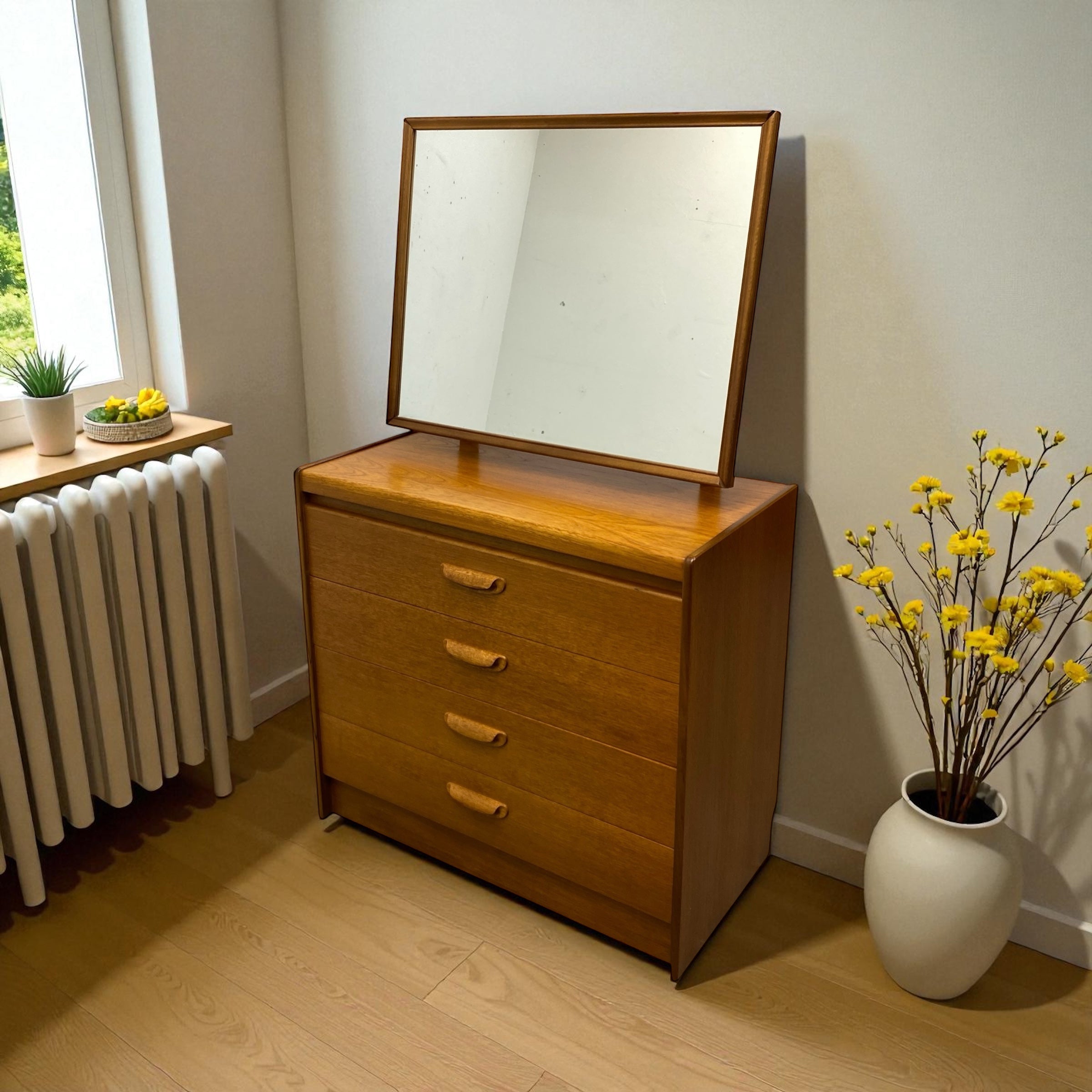 Wooden dresser with mirror next to a radiator and a vase of yellow flowers on a wooden floor.