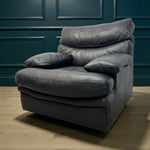 Load image into Gallery viewer, BLACK leather armchair against a dark blue paneled wall.
