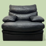 Load image into Gallery viewer, Black leather armchair on a light green background
