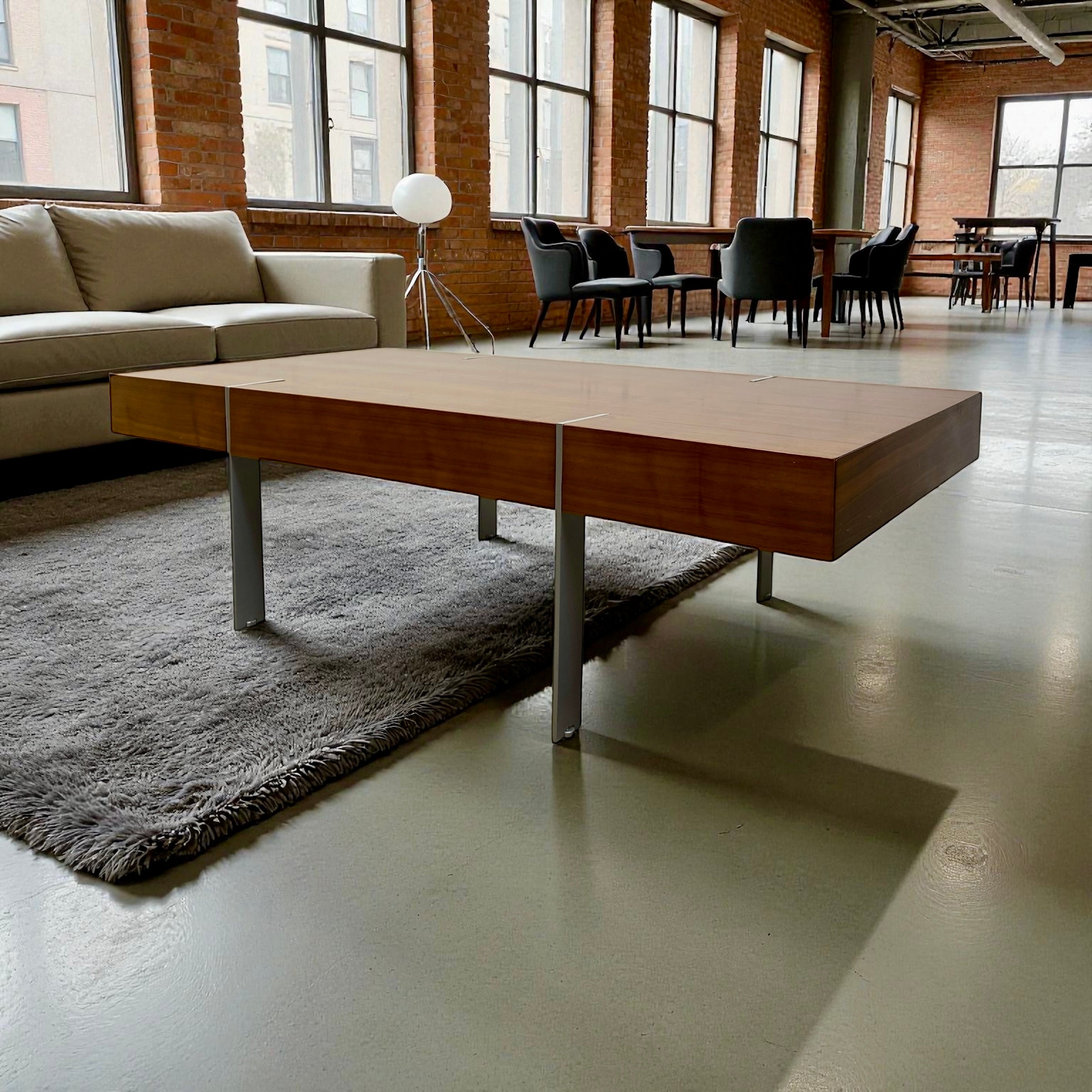 Modern coffee table in a room with large windows and a couch.