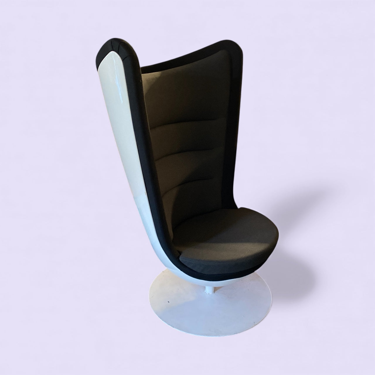 Modern chair with black cushioned seat and white base on a light purple background