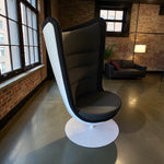Load image into Gallery viewer, Modern chair with a white base in a room with brick walls and large windows.
