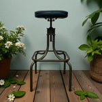 Load image into Gallery viewer, Vintage-style stool with black seat on a wooden floor with plants
