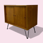 Load image into Gallery viewer, Wooden cabinet with black legs on a light pink background
