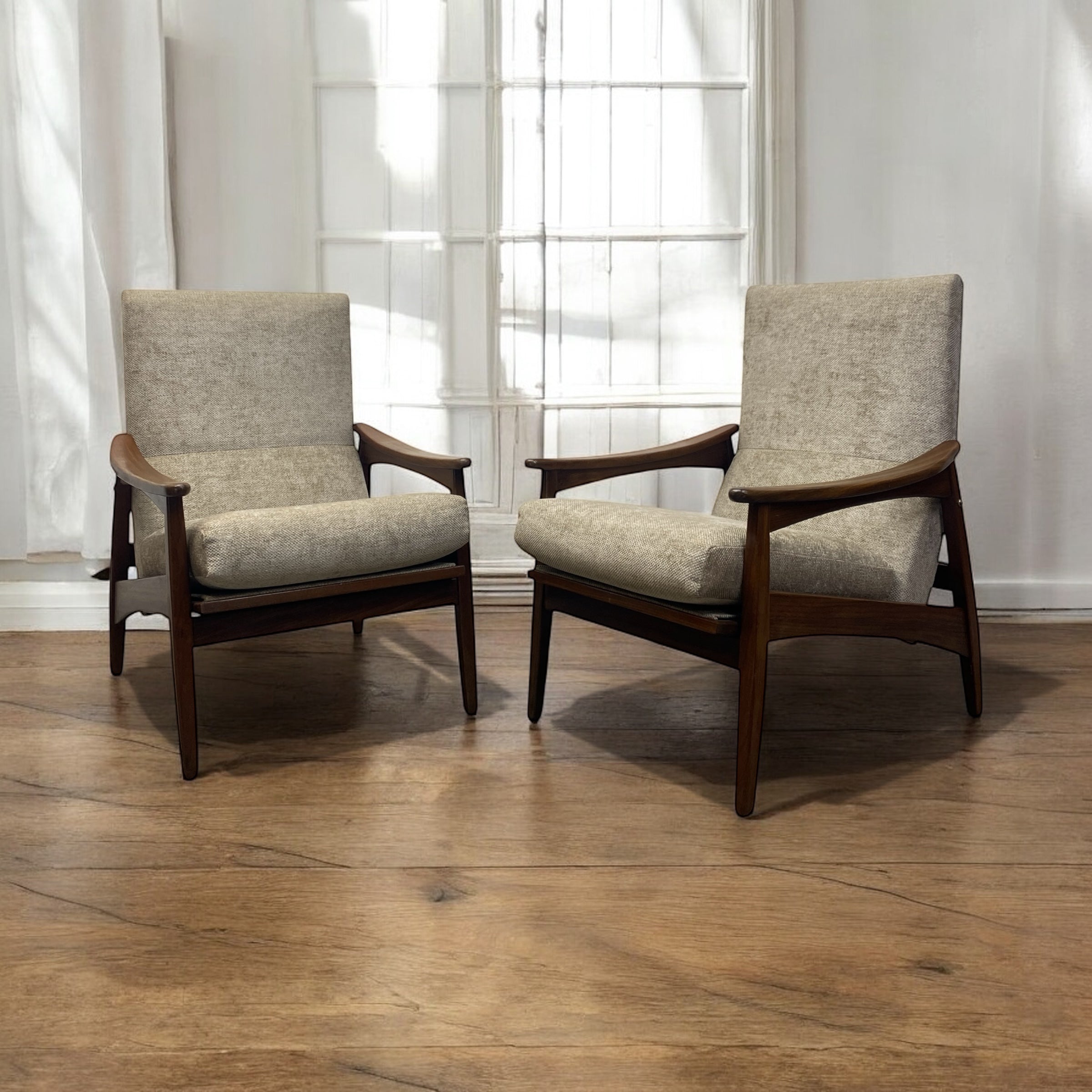 two lounge chairs on a wooden floor with white curtains