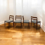 Load image into Gallery viewer, Four wooden chairs with gray cushions on a wooden floor.
