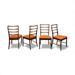 Load image into Gallery viewer, Four wooden chairs with orange cushions on a white background
