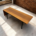 Load image into Gallery viewer, Wooden table with black legs on a concrete floor with a brick wall background
