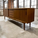 Load image into Gallery viewer, Wooden sideboard in a room with large windows and concrete floor
