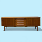 Load image into Gallery viewer, Wooden sideboard with drawers on a light blue background
